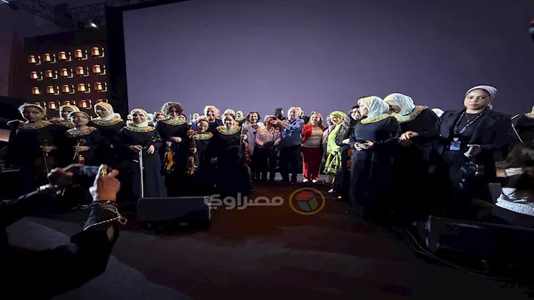أعضاء أوركسترا النور والأمل يلتقطون صورا مع المهندس سميح ساويرس في حفل سيني جونة
